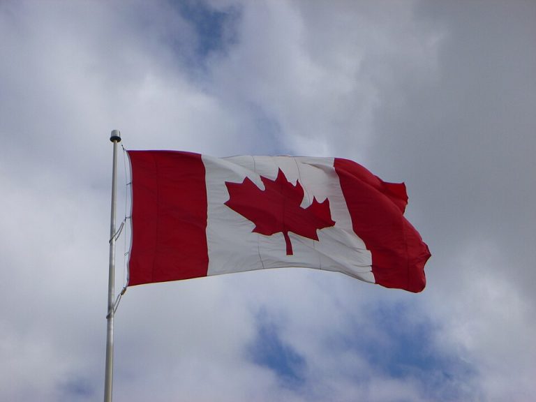 A contemporary Canadian flag in flight; not a photograph of the first raising in 1965.