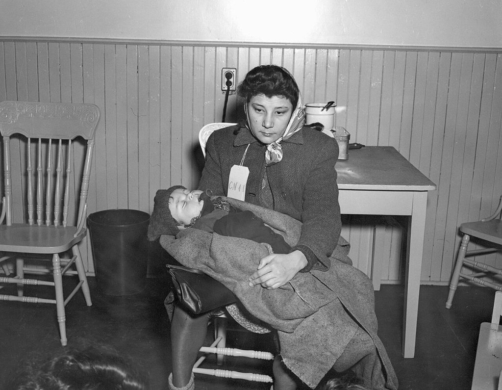 An immigrant woman with her baby at Pier 21, Halifax, in 1948 (photograph by E. A. Bollinger).
