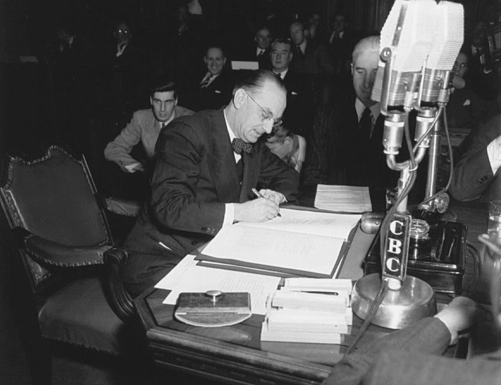 Joey Smallwood signing the agreement admitting Newfoundland into Confederation, Ottawa, December 1948 (National Film Board).